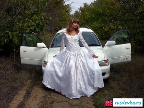Модель в свадебном платье у машине