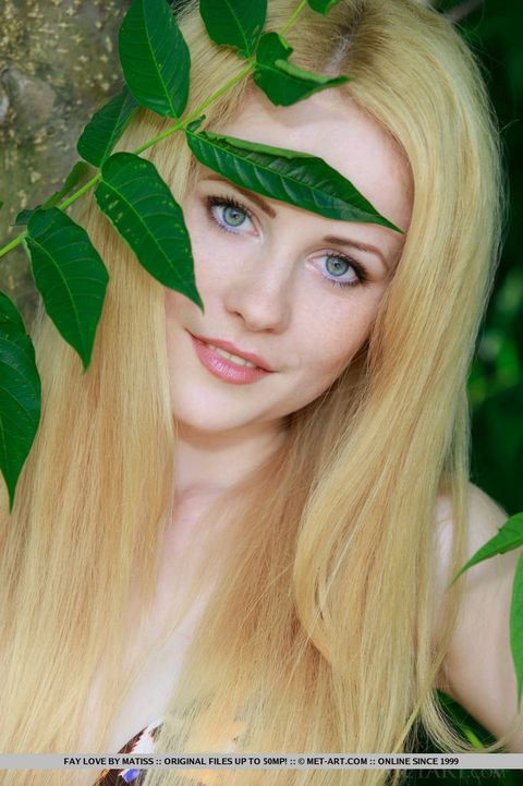 Молодая блондиночка спряталась около дерева и обнажила вульву на камеру